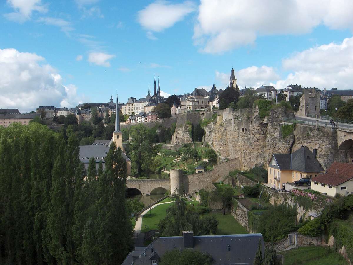 Luxembourg City's old town on the cliffs above the green Alzette valley under a blue sky